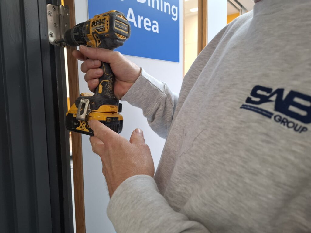 Fire door installation in Norfolk being installed by quailidied fire door installer from SAB Group
